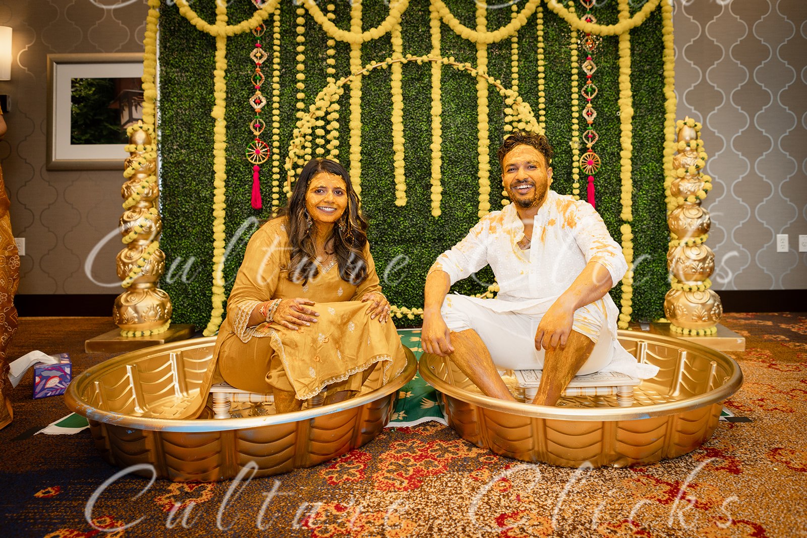 A couple during a Haldi ceremony with marigold garlands