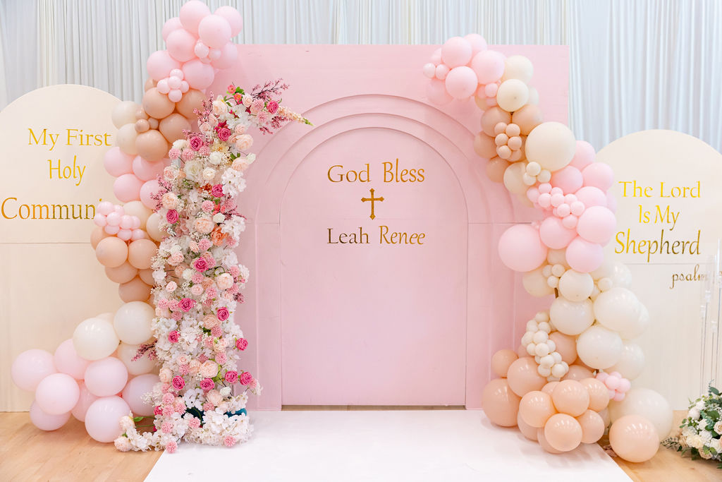 An elegant pastel balloon installation with florals for a milestone celebration