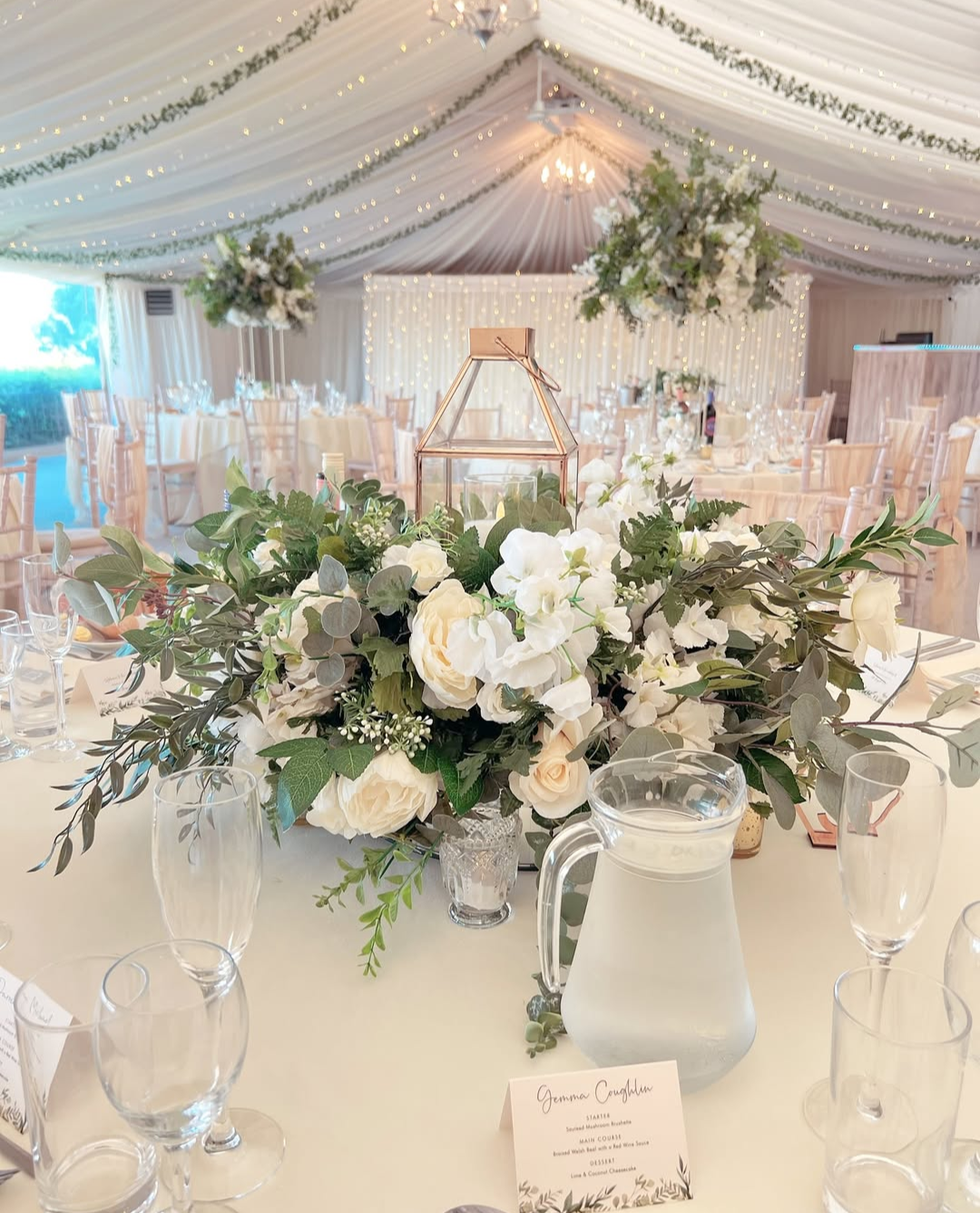 Elegant white and green wedding tablescape in a marquee tent