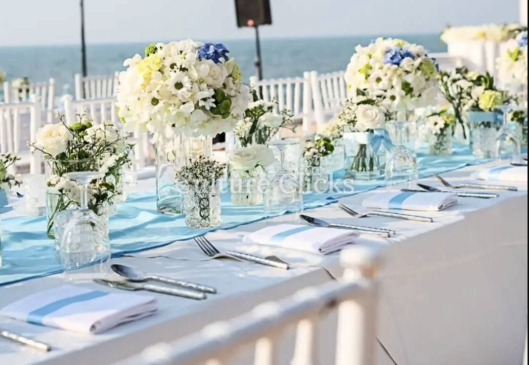 Waterfront wedding table with white and blue florals and a pale blue runner