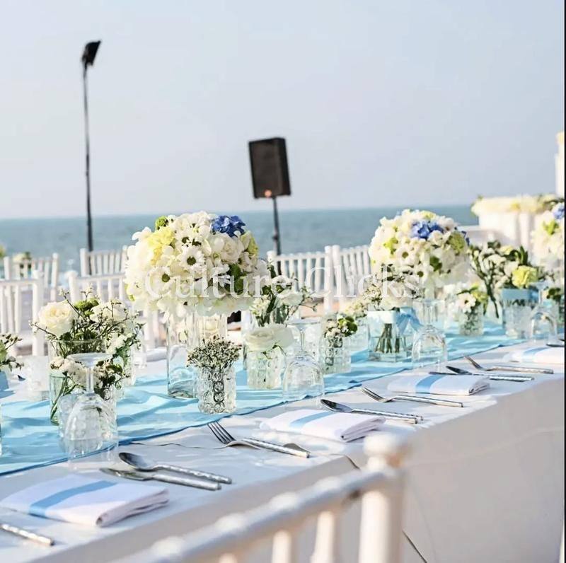 Long waterfront table with white florals and blue runner
