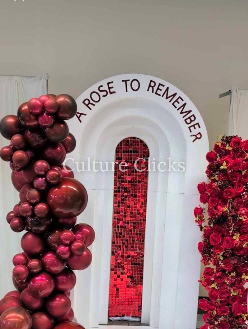 A Rose to Remember arch with burgundy balloons and red roses