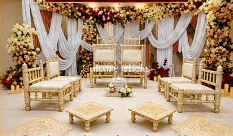 Wedding stage with white drapes, floral garlands and ivory ceremony seating